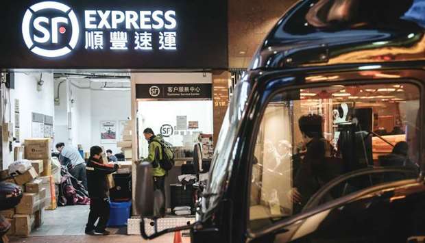 Employees handle packages at an SF Express store in Hong Kong. SF Holding, one of the largest Chinese package-delivery services, is exploring a potential investment in Robert Kuoku2019s listed logistics business, people with knowledge of the matter said.