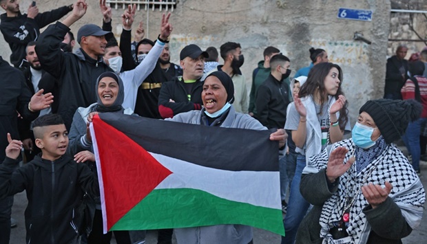 A woman waves a Palestinian flag during a protest in the flashpoint neighbourhood of Sheikh Jarrah in annexed east Jerusalem, yesterday.