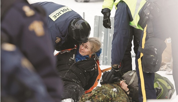 ?* Canadian police officers detain protestors as they work to restore normality to the capital while trucks and demonstrators continue to occupy the downtown core for more than three weeks to protest against pandemic restrictions in Ottawa yesterday. (Reuters)
