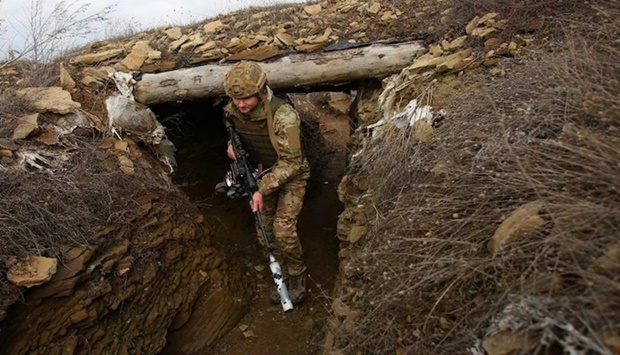 A Ukrainian serviceman walks along a trench at a position on the front line with Russia-backed separatists near the settlement of Troitske in the Lugansk region.