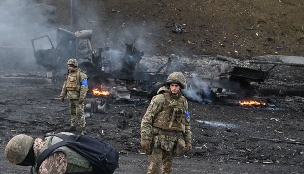 Ukrainian service members look for and collect unexploded shells after a fighting with Russian raiding group in the Ukrainian capital of Kyiv in the morning of February 26, according to Ukrainian service personnel at the scene. Sergei Supinsky/AFP