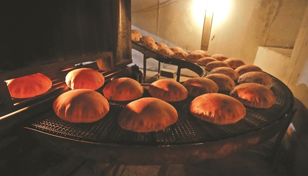 This file photo shows freshly-baked bread moving along a production line out of an oven at an automated bakery in Beirut.