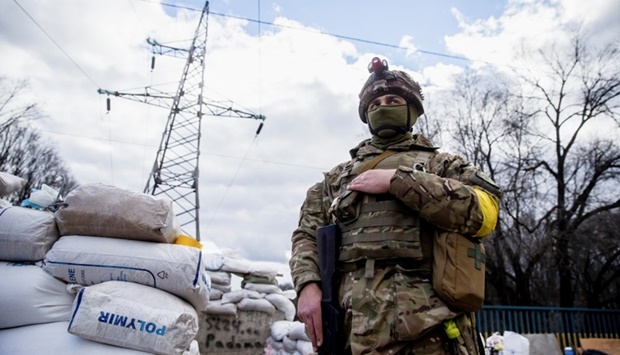 A Ukrainian service member is seen, after Russia launched a massive military operation against Ukraine, at a check point in the city of Zhytomyr, Ukraine February 27. REUTERS