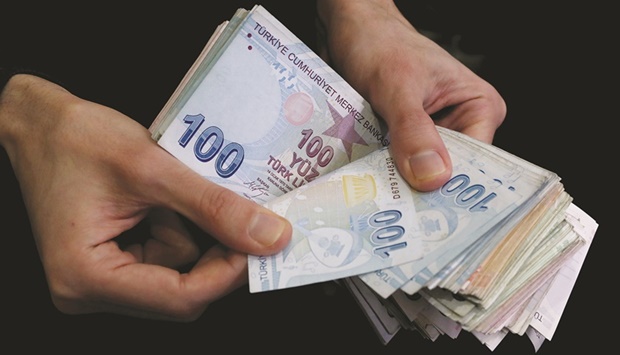 A merchant counts Turkish lira banknotes at the Grand Bazaar in Istanbul (file). Turkeyu2019s consumer prices surged by a stronger-than-expected 48.7% from the same period in January last year, up from an annual rate of 36.1% in December, according to the Turkish statistics agency.