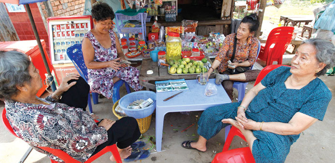   Vietnamese women sit at a shop in their community in Phnom Penh, Cambodia.