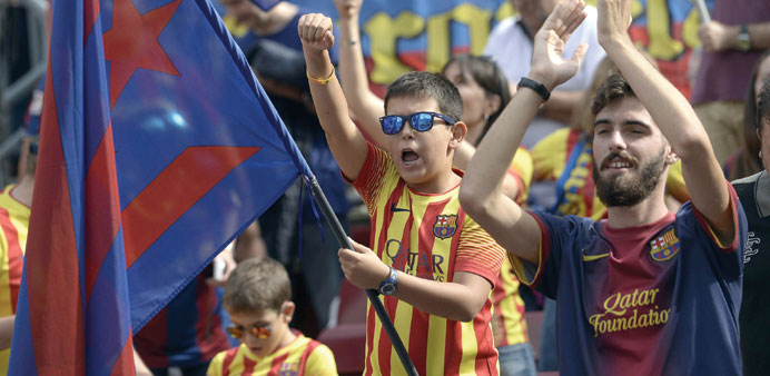 A young FC Barcelona supporter waves an u2018esteladau2019 (Catalan pro-independence flag) with FC Barcelonau2019s colours before a Spanish league football match 