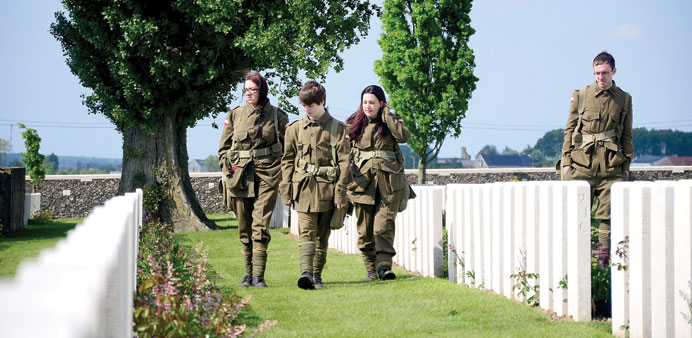 PAYING RESPECTS: Teenagers from England suit up for a living history visit at Tyne Cot Commonwealth War Graves Cemetery outside Ypres.