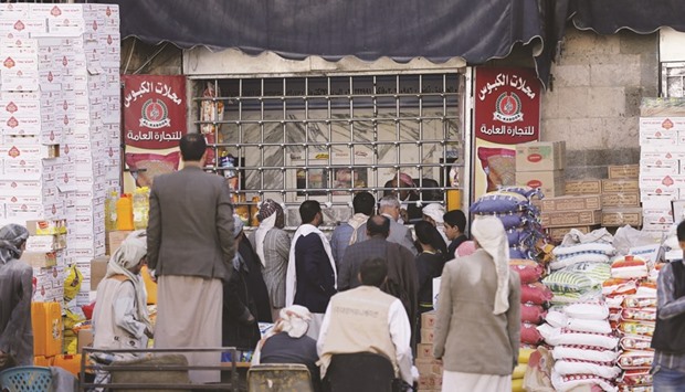 People gather outside a foodstuff store in Yemenu2019s capital Sanaa.