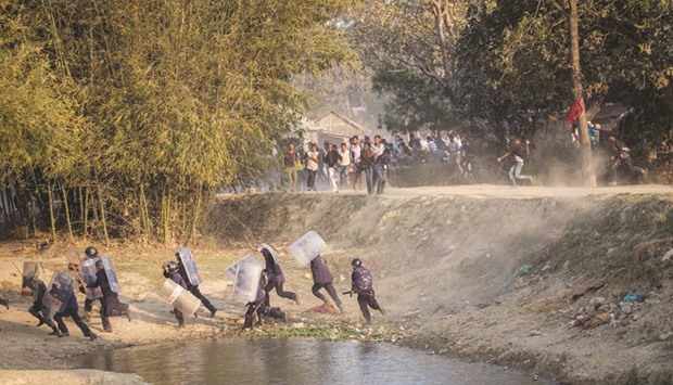 Riot police run for cover as Madhesi activists hurl stones at them in Saptari district of Nepal. Picture taken March 6.