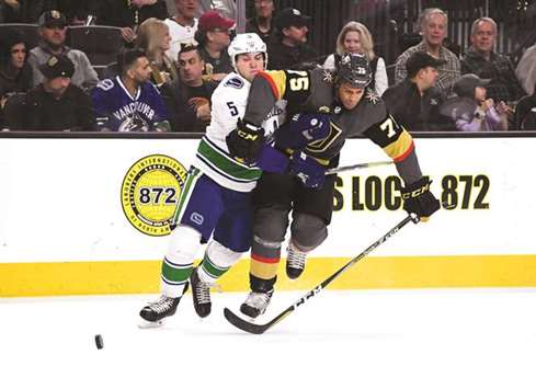 Vancouver Canucks Derrick Pouliot (left) and Vegas Golden Knightsu2019 Ryan Reaves battle for the puck during the NHL game in Las Vegas. (USA TODAY Sports)