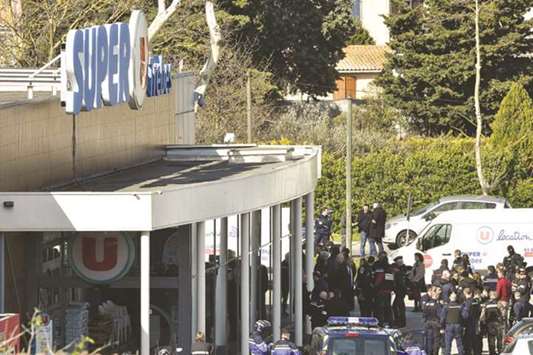 Security and police personnel are seen outside the Super U supermarket in Trebes, southern France, where a man took hostages, killing at least two before he was killed by security forces.