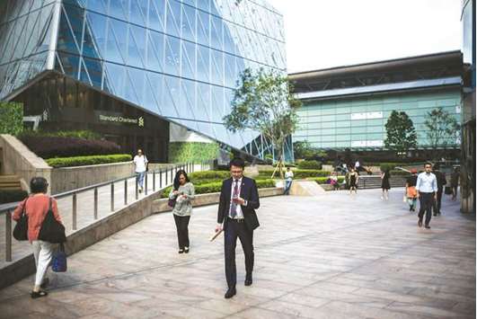 People walk outside the Hong Kong Stock Exchange building. The Hang Seng closed down 0.1% to 30,268.77 points yesterday.