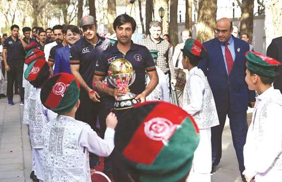 Afghan cricket captain Asghar Stanikzai (centre) and teammate Mohammed Nabi (centre left) arrive for an event to celebrate the team's qualification to the 2019 World Cup, in Kabul yesterday. (AFP)