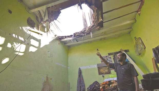 A picture taken on Monday in Um Al-Hammam district in Riyadh shows a man looking at a hole in a household ceiling caused by missile debris.