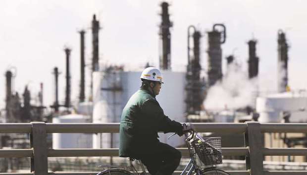 A worker cycles near a factory at the Keihin industrial zone in Kawasaki. Japanu2019s industrial production rebounded in February from a large decline in the previous month and companies forecast further gains in coming months in a sign that factory output is back on the path towards expansion.