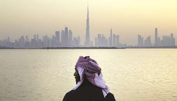 An Emirati man looks out from the Dubai Creek Habour Development towards the Burj Khalifa tower (centre) and other skyscrapers in Dubai (file). Real-estate prices in Dubai have fallen about 22% since the end of 2014, according to data from the Bank of International Settlements.