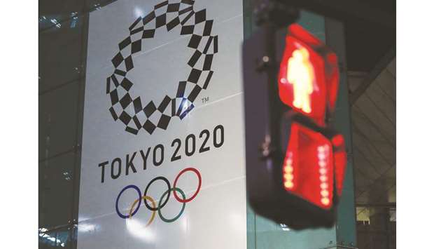 A banner for the upcoming Tokyo 2020 Olympics is seen through a traffic signal in Tokyo yesterday. (Reuters)
