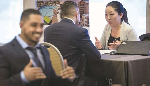 A representative (right) speaks with a job seeker at the San Francisco Career Fair & Job Fair in Burlingame. Labour market strength was underscored by other data yesterday showing planned job cuts by US-based employers fell sharply in February.