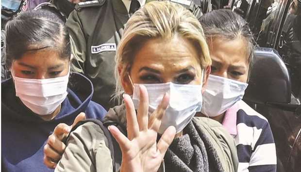 Anez waves as she is escorted into the Obrajes prison in La Paz.