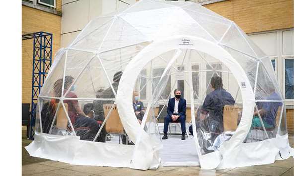 Britain's main opposition Labour Party leader Keir Starmer (C) speaks with nurses and midwives inside a pop-up dome during a visit to the Whittington hospital in London