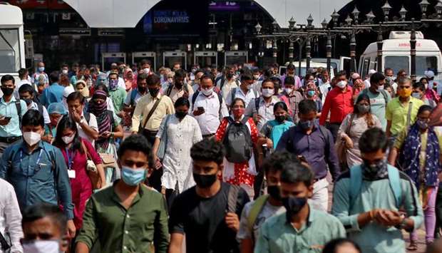 People wearing protective face masks leave the Chhatrapati Shivaji Terminus railway station, in Mumbai