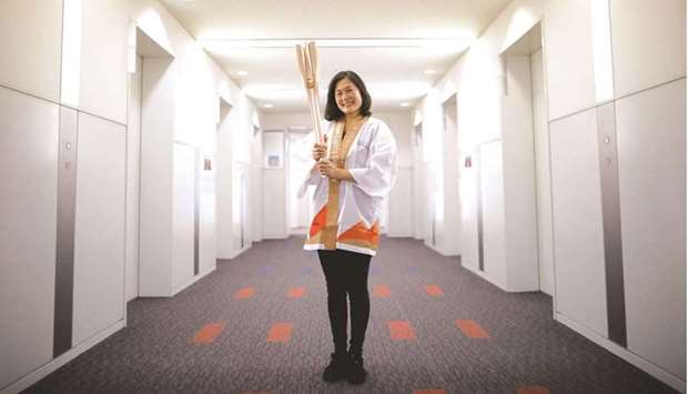 Hiromi Kawamura, Senior Director of Planning and International Co-ordination for Tokyo 2020 Torch Relay, holding the torch of the Tokyo 2020 Olympic Games, poses ahead of the start of the Torch Relay in Tokyo, Japan, yesterday. (Reuters)