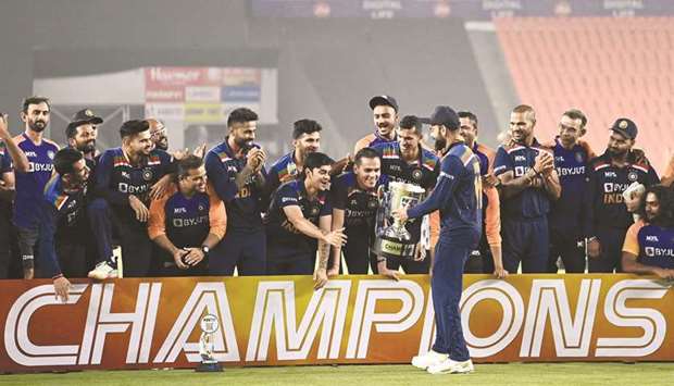 Indiau2019s captain Virat Kohli (centre) holds the trophy as his teammates celebrate after winning the Twenty20 series against England in Ahmedabad yesterday. (AFP)