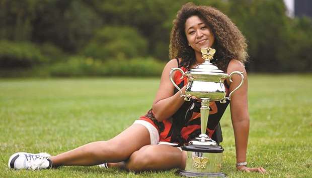 Australian Open champion Japanu2019s Naomi Osaka poses with the trophy at the Royal Botanic Gardens Victoria in Melbourne on February 21, 2021. (Reuters)