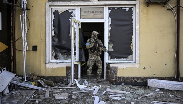 A Ukrainian serviceman exits a damaged building after shelling in Kyiv, on March 12, 2022.