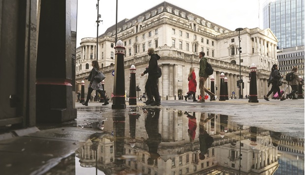Pedestrians pass the Bank of England in the City of London. Investors emboldened by the BoEu2019s  unexpectedly dovish tilt are loading up on UK government bonds as anxiety over the inflation outlook begins to give way to concerns about economic growth.