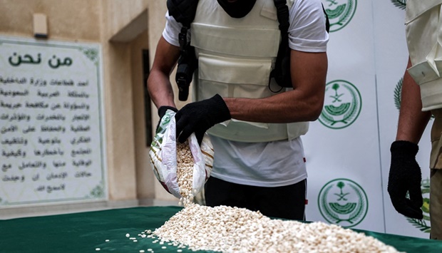 An officer of the Directorate of Narcotics Control of Saudi Arabia's Interior Ministry sorts through tablets of captagon (Fenethylline) seized during a special operation  in the Red Sea coastal city of Jeddah on March 1, 2022.