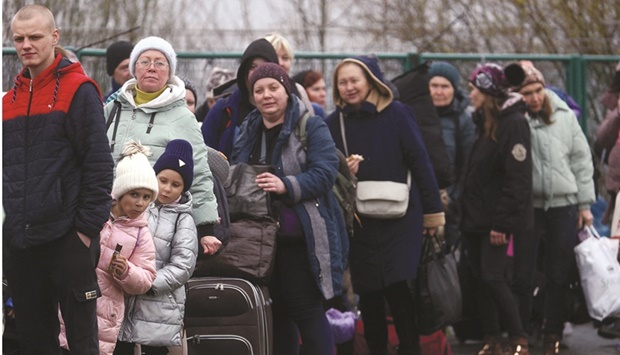 Ukrainian refugees wait in line to cross the Ukraine-Poland border, after fleeing the Russian invasion of Ukraine, outside the border crossing checkpoint in Shehyni, Ukraine, yesterday.