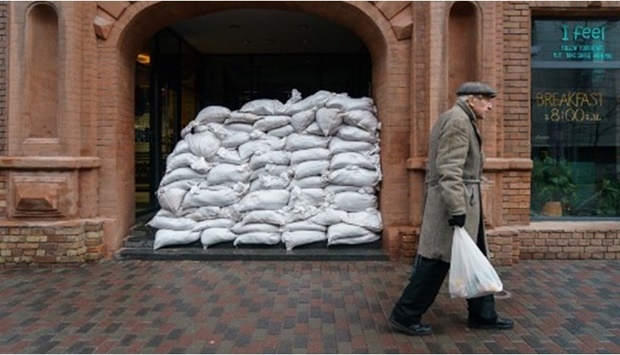 A man walks past sandbags protecting the entrance of a cafe in the Ukrainian city of Dnipro, the industrial hub, which sits on the western side of the Dnieper river and divides east and central Ukraine, on March 2, 2022.