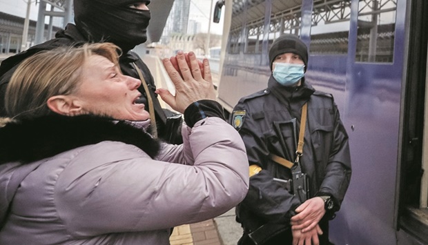 A woman reacts as an evacuation train with children from Kyivu2019s Central Childrenu2019s Hospital departs to Lviv at Kyiv central train station yesterday. (Reuters)