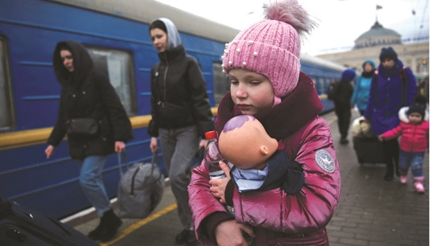 A girl holds a doll as civilians fleeing Russiau2019s invasion of Ukraine board a train, in Odessa, Ukraine, yesterday.