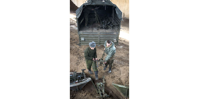 Militants of the self-proclaimed u2018Peopleu2019s Republic of Donetsku2019 unload 120mm mortars from a truck, in a hangar in Snizhne, east of Donetsk.