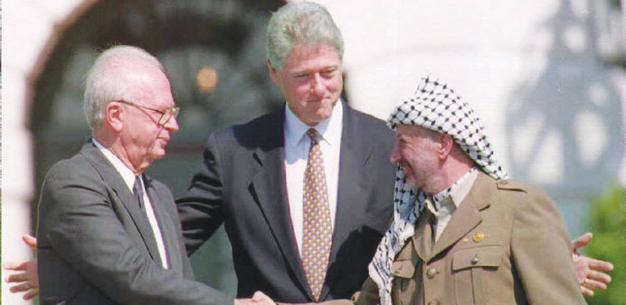 A picture taken on September 13, 1993 shows US President Bill Clinton standing between PLO leader Yasser Arafat as he shakes hands with Israeli Prime 