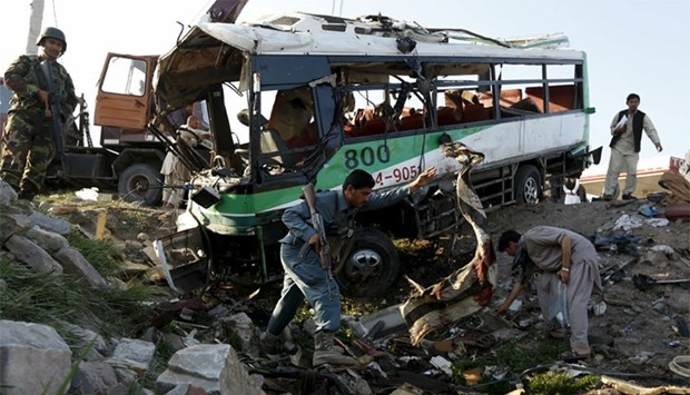 Afghan policemen inspect next to a damaged police vehicle after a suicide attack in Jalalabad, eastern Afghanistan. Reuters