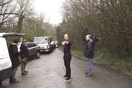 Masters Champion Danny Willett directs traffic in Lindrick Dale, UK, as heavy traffic means he is unable to drive his car into his home after arriving back. (Reuters)