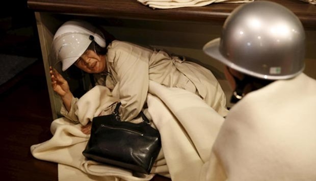 A woman takes shelter after another earthquake hit the area at a hotel in Kumamoto, southern Japan.