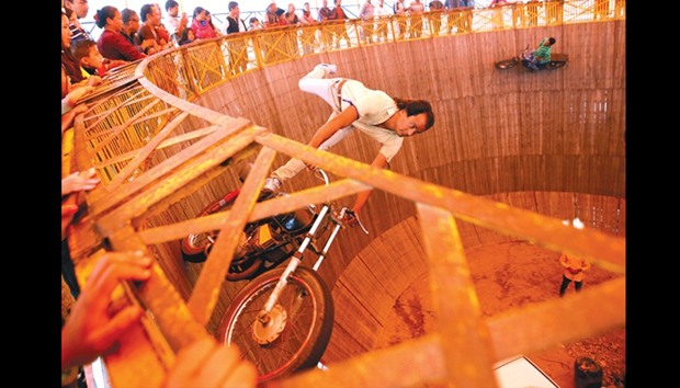 A stuntman rides a motorcycle inside the Well of Death attraction during a fair in Bhaktapur, Nepal.