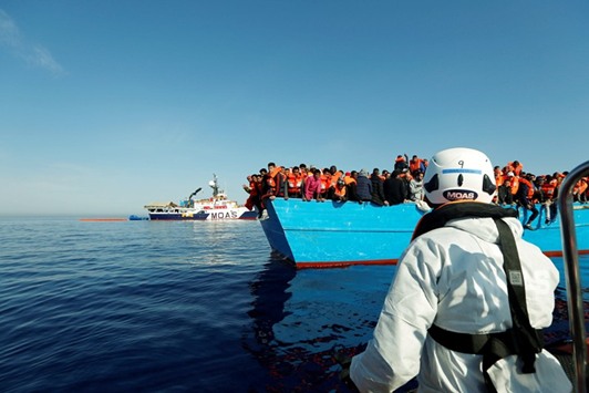 Rescuers from the Malta-based NGO Migrant Offshore Aid Station (MOAS) ship Phoenix approach migrants in a wooden boat in the Mediterranean off the coast of Sabratha in Libya yesterday.