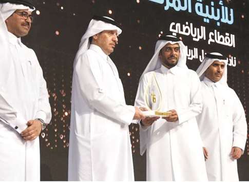 HE the Prime Minister and Interior Minister Sheikh Abdullah bin Nasser bin Khalifa al-Thani presents the award to Msheireb Propertiesu2019 acting CEO Ali al-Kuwari as HE the Minister of Energy and Industry Dr Mohamed bin Saleh al-Sada and Kahramaa president Essa bin Hilal al-Kuwari look on.