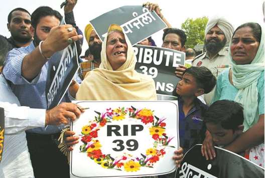 A relative of one of the 38 construction workers who were killed by Islamic State militants in Iraq in 2014, mourns as she waits for bodies to arrive outside the airport in Amritsar yesterday.