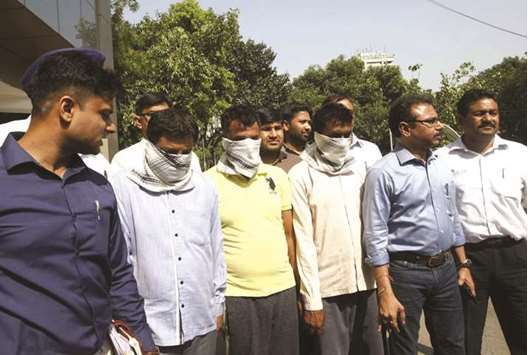 Delhi Police crime branch officials with the three suspects arrested in connection with the CBSE Class XII economics paper leak, in New Delhi yesterday.