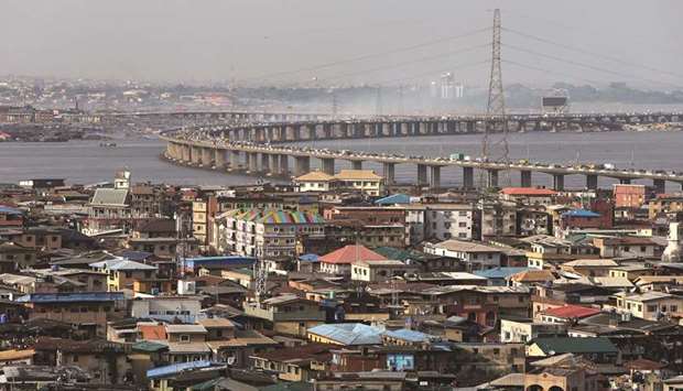 Electricity pylons carry power cables above residential property as traffic passes across a bridge from Isale Eko on Lagos Island towards the mainland in Lagos, Nigeria (file). Upgrading inadequate infrastructure in Africau2019s most-populous nation is among President Muhammadu Buhariu2019s priorities for this second four-year term, along with improving security and strengthening an economy, which contracted in 2016.