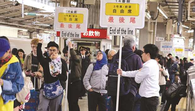 Passengers wait for a train at Tokyo railway station yesterday, beginning of the unprecedented 10-day Golden Week holiday.
