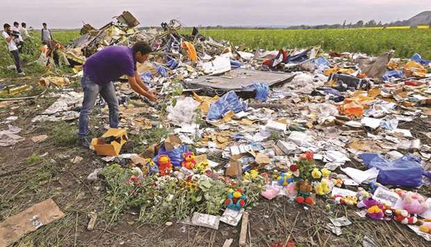 This picture taken on July 19, 2014 shows a journalist inspecting debris from Malaysia Airlines flight MH17.