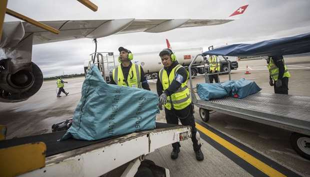 Ground crew move cargo from a passenger aircraft at the London City Airport (file).