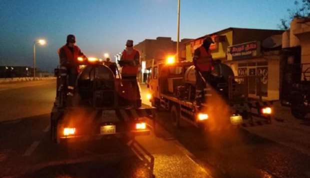 Workers disinfect a street.